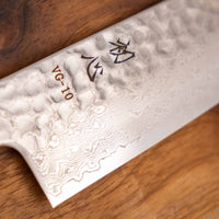 Detajl damascus vzorca na rezilu noža Hayabusa Santoku VG-10 Tsuchime Damascus Ebony 180 mm, ki poudarja prefinjeno estetiko in kakovostno izdelavo.