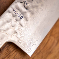 Detajl damascus vzorca na rezilu noža Hayabusa Santoku VG-10 Tsuchime Damascus Ebony 180 mm, ki poudarja prefinjeno estetiko in kakovostno izdelavo.