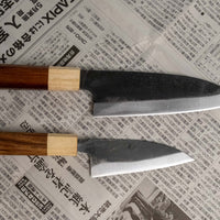 Spoznajte set ročno kovanih nožev iz visokoogljičnega jekla, ki je kos skoraj vsem rezalim opravilom v kuhinji - razen zares velikim kosom mesa. Set sestavljata Yoshida Ajikiri 100 mm in Santoku Funayuki 155mm. Izdelani sta iz SUJ-2 jekla in opremljeni z oktagonalnim japonskim ročajem iz palisandra in japonske cedre.