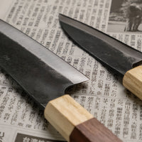 Spoznajte set ročno kovanih nožev iz visokoogljičnega jekla, ki je kos skoraj vsem rezalim opravilom v kuhinji - razen zares velikim kosom mesa. Set sestavljata Yoshida Ajikiri 100 mm in Santoku Funayuki 155mm. Izdelani sta iz SUJ-2 jekla in opremljeni z oktagonalnim japonskim ročajem iz palisandra in japonske cedre.