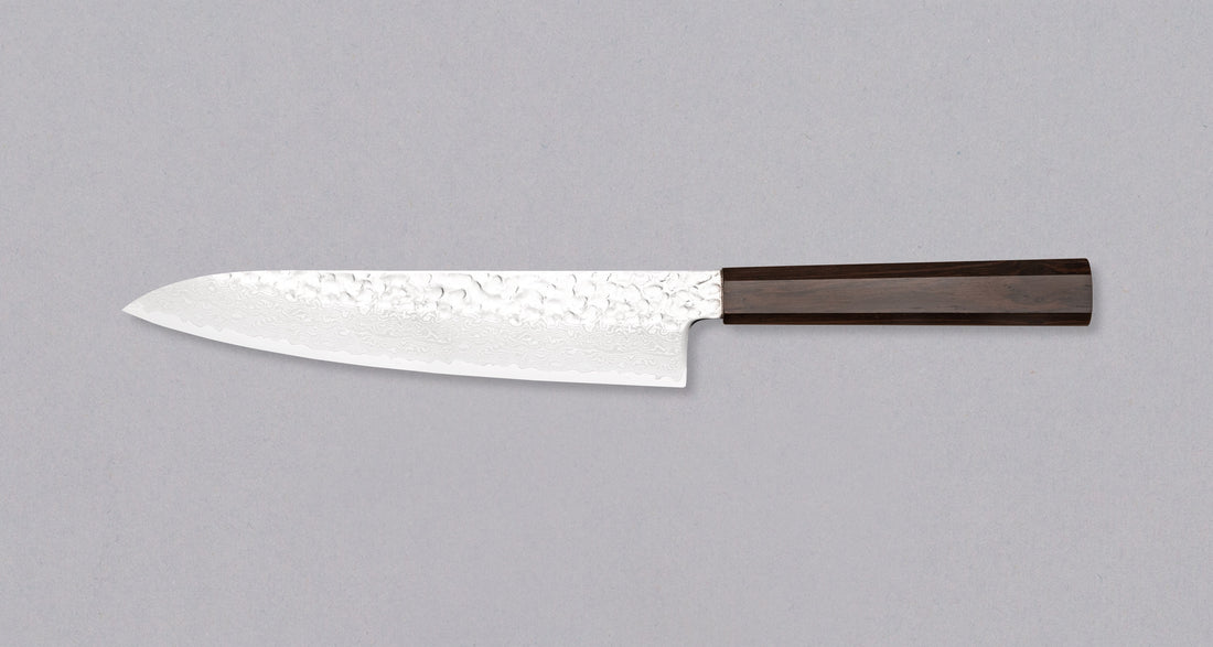 Leva stran noža Hayabusa Gyuto VG-10 Tsuchime Damascus Ebony 210 mm, prikazuje celotno rezilo z damask vzorcem in ergonomskim ročajem iz ebanovine.