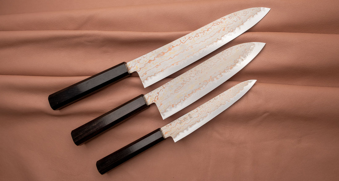 Hayabusa Gyuto Aogami #2 Rainbow Damascus 210 mm je nož za vsestransko uporabo v kuhinji, primeren za meso, ribe in zelenjavo. Tanko rezilo je narejeno iz Aogami #2 jekla, znanega po dolgem ohranjanju ostrine in lahkosti brušenja. Ima unikaten barvit damaščanski vzorec, izdelan s plastenjem medenine in bakra.