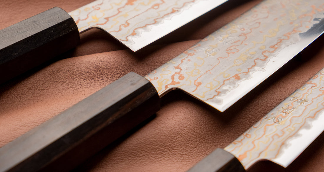 Hayabusa Gyuto Aogami #2 Rainbow Damascus 210 mm je nož za vsestransko uporabo v kuhinji, primeren za meso, ribe in zelenjavo. Tanko rezilo je narejeno iz Aogami #2 jekla, znanega po dolgem ohranjanju ostrine in lahkosti brušenja. Ima unikaten barvit damaščanski vzorec, izdelan s plastenjem medenine in bakra.
