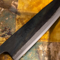 Prikaz detajlov Kokugei Gyuto Aogami #1 Kuro-uchi, z jasnimi robovi črne obdelave in vidnimi značilnostmi ročno izdelanega noža.