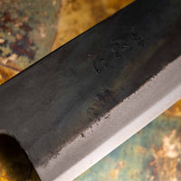 Prikaz detajlov Kokugei Gyuto Aogami #1 Kuro-uchi, z jasnimi robovi črne obdelave in vidnimi značilnostmi ročno izdelanega noža.