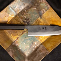 Kokugei Santoku Aogami #1 Kuro-uchi Ebony 165 mm je vsestranski japonski kuhinjski nož, namenjen za pripravo mesa, rib in zelenjave.