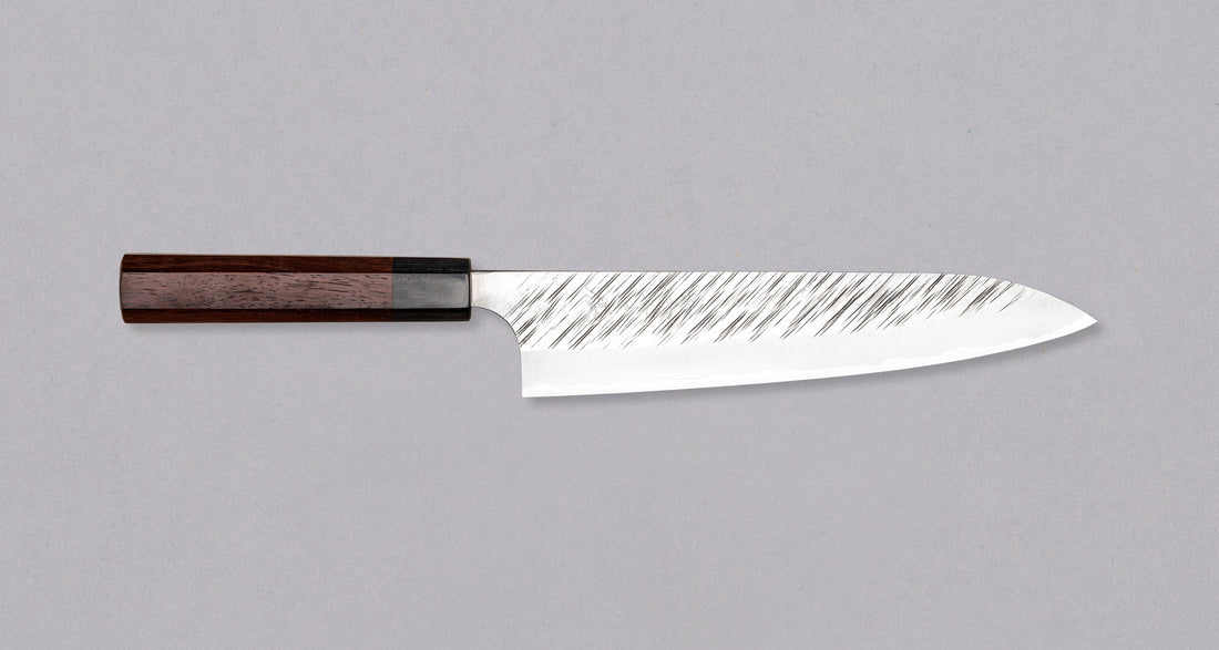 Kurosaki Gyuto Fujin je še eno unikatno rezilo iz rok nadarjenega kovaškega mojstra Yu Kurosakija. Fujin je japonski bog vetra in en najstarejših bogov šintoizma, zato črte na rezilu spominjajo na sunke viharja. Rezilo je izdelano iz SG2 prašnega jekla in ima ročaj iz palisandra s pakka obročkom. Zbirateljski kos!