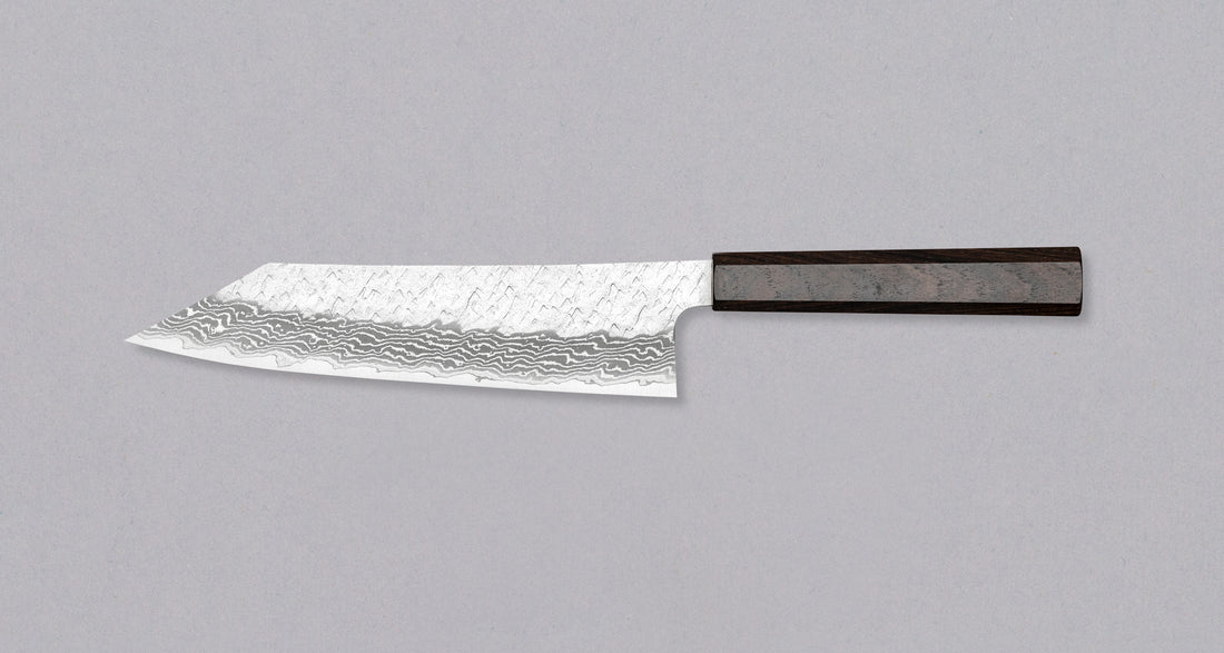 Nigara Kiritsuke Gyuto VG-10 Damascus Tsuchime 210 mm je večnamenski japonski kuhinjski nož, primeren za pripravo mesa, rib in zelenjave. Jedro iz nerjavečega VG-10 jekla zagotavlja dolgotrajno ostrino ter minimalno vzdrževanje. Izjemne lastnosti in videz rezila dopolnjuje ročaj japonskega tipa (Wa) iz luksuzne ebenovine.