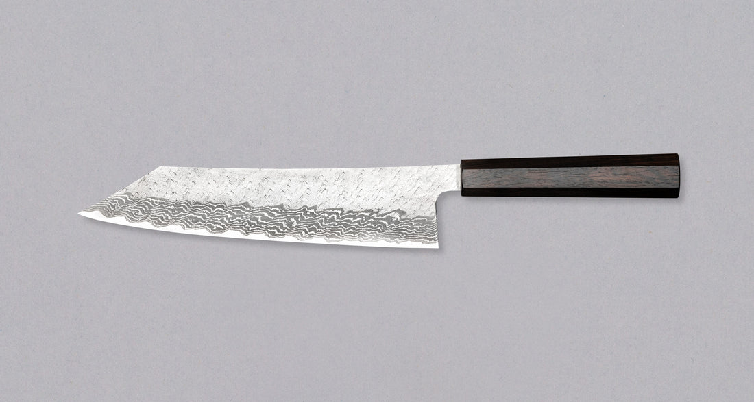 Nigara Kiritsuke Gyuto VG-10 Damascus Tsuchime 240 mm je večnamenski japonski kuhinjski nož, primeren za pripravo mesa, rib in zelenjave. Jedro iz nerjavečega VG-10 jekla zagotavlja dolgotrajno ostrino ter minimalno vzdrževanje. Izjemne lastnosti in videz rezila dopolnjuje ročaj japonskega tipa (Wa) iz luksuzne ebenovine.
