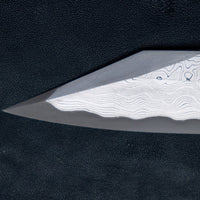 Nigara Kurozome Kiritsuke Yanagiba Aogami #2 Damascus 240 mm je tradicionalni japonski nož, ki se uporablja za pripravo rib (zlasti za sashimi in nigiri sushi). Dolgo rezilo omogoča lepe in dolge gibe, prirezana konica pa natančen zaključek reza.