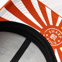 OsterRob ekskluziven merch: OsterRob x Vincent Trinidad kapa Ekskluziven OsterRob dizajn rjavega medveda sumoborca, oboroženega z našim ZDP-189 Bunka Black japonskim nožem, ki je plod sodelovanja z umetnikom Vincentom Trinidadom. Na spodnjem delu vizirja kape je logotip SharpEdge, ki krasi japonsko vzhajajoče sonce.