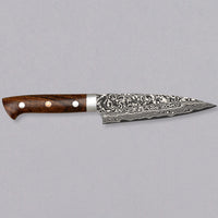 Saji Petty R2 Ironwood 130 mm je nož kovača Takeshi Sajija. Saji je kovač tretje generacije iz slavnega kovaškega središča Takefu Knife Village. S svojo novo omejeno serijo Rainbow Damascus je ustvaril mojstrske nože iz prašnega jekla R2 s temnim damask vzorcem.