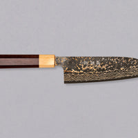 Saji Santoku VG-10 Gold RWO 165 mm je vsestranski japonski kuhinjski nož, primeren za pripravo mesa, rib in zelenjave. Vendar bi mu delali krivico, če bi ga imenovali samo kuhinjski nož, saj je resnično izjemen primerek japonske kovaške spretnosti, od njegovega videza in vse do specifičnih detajlov.