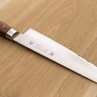 Tamahagane Gyuto je vsestranski nož za pestro paleto načinov rezanja v kuhinji. Z njim je enostavno sekljati zelenjavo in rezati večje kose mesa, tanka konica pa je primerna za natančno pripravo hrane. Gyuto je zvesti pomočnik v kuhinji, ki vam olajša dolgotrajnejšo pripravo jedi.