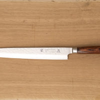 Tamahagane "TSUBAME" Sashimi-Slicer 210mm je izdelan iz VG-5 nerjavečega jekla in ima zelo vzdržljiv in vodoodporen ročaj iz pakka lesa. Izjemno nezahteven in zanesljiv nož, primeren za profesionalne kuharje.