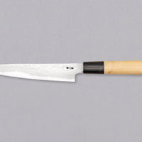 Tanaka Petty Aogami #2 Damascus 150mm je odlična izbira za vse kuharje, ki želijo ročno kovan japonski nož iz tradicionalnega jekla s pravo japonsko fino ostrino. Nož z minimalističnim zaključnim videzom na rezilu in klasičnim wa ročajem iz lesa magnolije pooseblja japonsko estetiko. Pride v paulownia leseni škatlici.
