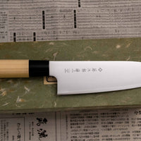 Tojiro Santoku Zen 165 mm je nož priznanega proizvajalca Tojiro, ki ga zaznamuje japonski ročaj iz magnolije, minimalistično oblikovano rezilo in trda zlitina jekla. Rezultat je lahek, oster, vsestranski kuhinjski nož za domače in poklicne kuharje z rezilom, ki je zelo odporno na rjo in se enostavno ponovno nabrusi.