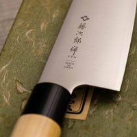 Tojiro Santoku Zen 165 mm je nož priznanega proizvajalca Tojiro, ki ga zaznamuje japonski ročaj iz magnolije, minimalistično oblikovano rezilo in trda zlitina jekla. Rezultat je lahek, oster, vsestranski kuhinjski nož za domače in poklicne kuharje z rezilom, ki je zelo odporno na rjo in se enostavno ponovno nabrusi.