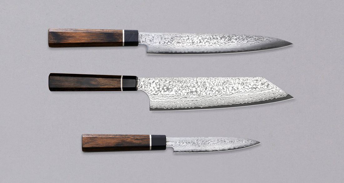 Black Damascus linija je naša linija nožev s 33-slojnim damask vzorcem, zaradi katerega je vsak kos unikaten. Senzo Black Damascus se kuje v kovačiji Suncraft. Ta set je sestavljen iz japonskih kuhinjskih nožev Black Damascus Slicer 210 mm, Black Damascus Bunka 200mm in Black Damascus Utility 120 mm, iz VG-10 jekla.