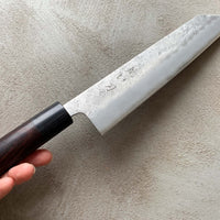 Hokiyama Kiritsuke Ginsanko Rosewood 210 mm_4 Čeprav je profil rezila Hokiyama Kiritsuke Ginsanko Rosewood nekoliko bolj raven kot pri Gyuto nožih, gre še vedno za večnamenski nož, primeren za vsakodnevno uporabo, saj je dolžina rezila 210 mm optimalna velikost za sekljanje zelenjave ter rezanje večjih kosov mesa in rib. Nož zaznamujejo odtisi kladiva nashiji.