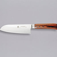 Tamahagane "SAN" Santoku 160 mm - Rezilo je kovano iz jekla VG-5 z visokim odstotkom ogljika, molibdenom in vanadijem ter z izjemno trdoto 61 HRC, rezalni rob je ročno brušen pod kotom med 14 in 15˚. Nož združuje popolno uravnoteženost med ostrino in trdnostjo, zato je primerno tudi za profesionalno delovno okolje.
