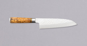 Saji Santoku R2 Karin 180 mm je vsestranski japonski kuhinjski nož, primeren za pripravo mesa, rib in zelenjave. R2/SG2 je jeklo brez kompromisov – visoka trdota okoli 64 HRC, odlična odpornost proti koroziji in enostavno brušenje. Drobni krožni odtisi kladivca preprečujejo prijemanje hrane na rezilo.