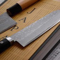 Masutani Santoku Damascus Black 170 mm_2 Masutani Santoku Damascus Black je japonski nož za zelenjavo, meso in ribe z damask vzorcem in yo pakka ročajem. Nož je izjemno tanek (1,8 mm), zato bo z lahkoto zdrsel skozi hrano, izbira jekla pa mu zagotavlja trpežnost in odpornost proti obrabi. Primeren je za nakup prvega japonskega kuhinjskega noža ali darilo.