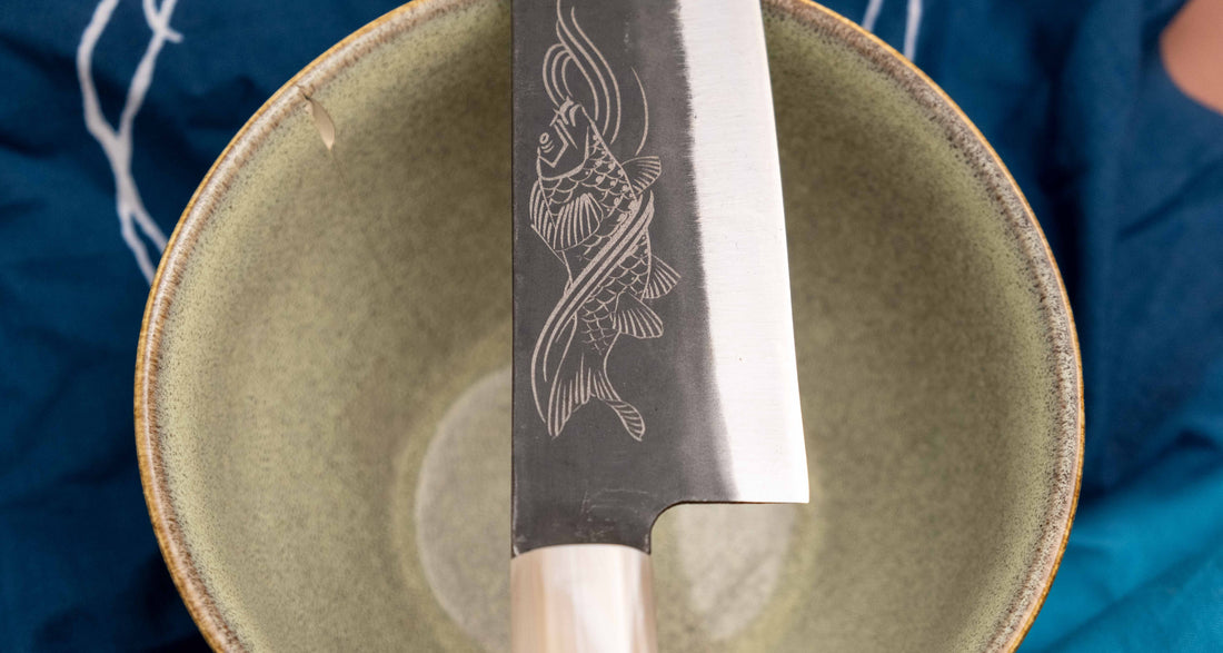 Yoshida Gyuto SUJ-2 Kuro-uchi 210 mm je ročno izdelan srednje velik kuhinjski nož, popoln za različna opravila v kuhinji. Kuro-uchi serija Yoshida Hamono združuje trpežno SUJ-2 jeklo (64,7 HRC) za izjemno obstojnost ostrine in kuro-uchi zaključek, ki zagotavlja rustikalen videz in dodatno zaščito rezila. Ročaj iz ebenovine omogoča varen oprijem in natančen nadzor pri rezanju. 