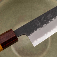 Japonski nož Hokiyama Bunka Aogami Super Kuro-uchi 170 mm je večnamenski nož iz Aogami Super jekla, ki dolgo časa drži ostrino. Kuro-uchi patina ga ščiti pred korozijo, odtisi kladiv pa preprečujejo lepljenje hrane na rezilo. Ima tradicionalni japonski wa ročaj oktagonalne oblike iz mahagonija in zelkovega lesa.