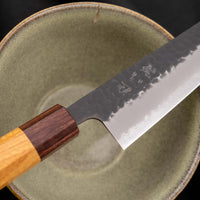 Japonski nož Hokiyama Bunka Aogami Super Kuro-uchi 170 mm je večnamenski nož iz Aogami Super jekla, ki dolgo časa drži ostrino. Kuro-uchi patina ga ščiti pred korozijo, odtisi kladiv pa preprečujejo lepljenje hrane na rezilo. Ima tradicionalni japonski wa ročaj oktagonalne oblike iz mahagonija in zelkovega lesa.