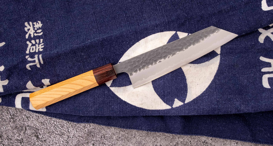 Japonski nož Hokiyama Bunka Aogami Super Kuro-uchi 170 mm je večnamenski nož iz Aogami Super jekla, ki dolgo časa drži ostrino. Kuro-uchi patina ga ščiti pred korozijo, odtisi kladiv pa preprečujejo lepljenje hrane na rezilo. Ima tradicionalni japonski wa ročaj oktagonalne oblike iz mahagonija in zelkovega lesa.