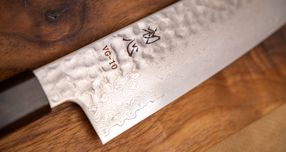 Detajl damascus vzorca na rezilu noža Hayabusa Santoku VG-10 Tsuchime Damascus Ebony 180 mm, ki poudarja prefinjeno estetiko in kakovostno izdelavo. 