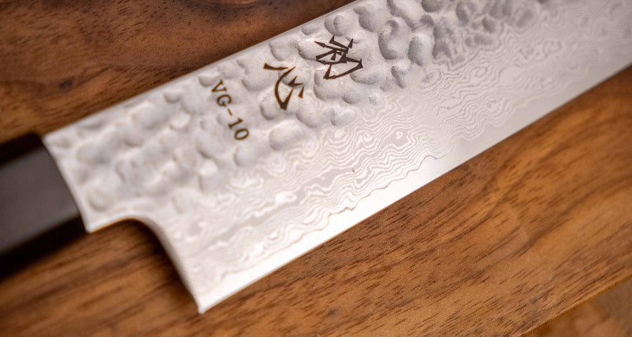 Detajl damascus vzorca na rezilu noža Hayabusa Sujihiki VG-10 Tsuchime Damascus Ebony 270 mm, ki poudarja prefinjeno estetiko in kakovostno izdelavo.