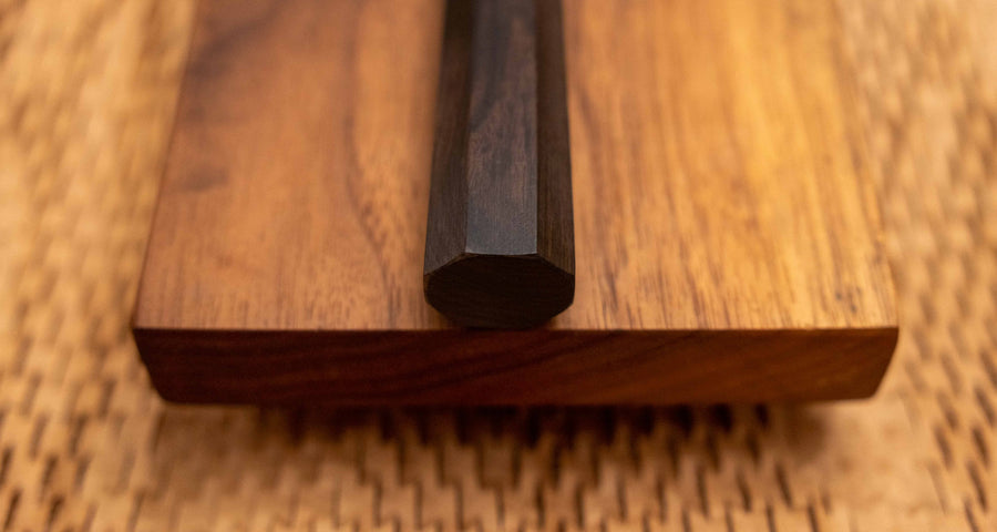 Pogled na osemkotni ročaj noža Hayabusa Sujihiki VG-10 Tsuchime Damascus Ebony 270 mm, izdelan iz temne ebenovine za stabilen in udoben oprijem.