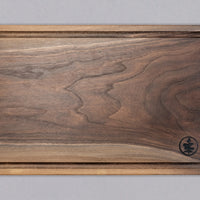 Ročno izdelana deska za rezanje je narejena iz temneg lesa ameriškega oreha. Z delovno površino 40 x 24 cm je ravno prave velikosti, da se prilega vsakemu pultu, najsi je to v domači ali profesionalni kuhinji. Zaradi svoje elegantne površine se lahko uporablja tudi kot servirna deska za postrežbo narezka.