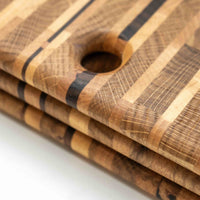 Ročno izdelana rezalna deska je sestavljena iz različnih vrst lesa. Z delovno površino približno 39 x 20 cm je ravno prave velikosti, da se prilega vsakemu pultu, tako doma kot v profesionalni kuhinji. "End grain" rezalne deske so zelo vzdržljive in poskrbijo, da je vaš nož dlje časa oster.