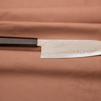 Hayabusa Santoku Aogami #2 Rainbow Damascus 180 mm je nož za vsestransko uporabo v kuhinji, primeren za meso, ribe in zelenjavo. Tanko rezilo je narejeno iz Aogami #2 jekla, znanega po dolgem ohranjanju ostrine in lahkosti brušenja. Ima unikaten barvit damaščanski vzorec, izdelan s plastenjem medenine in bakra.