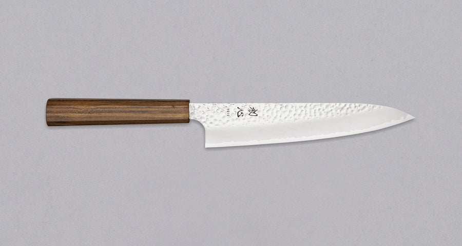 Hayabusa Gyuto VG-10 Tsuhime Bubinga 210 mm je vsestranski nož, ki je primeren za uporabo v domači in profesionalni kuhinji. Tanko in natančno rezilo iz vrhunskega VG-10 jekla omogoča enostavno delo tudi z drobnimi sestavinami. Nož izstopa s prefinjenim videzom: migaki rezilo krasi droben vzorec kladiva, medtem ko izrazita valovita linija ločuje plasti jekla in jedro, ustvarjajoč kontrast med matirano in sijočo površino.