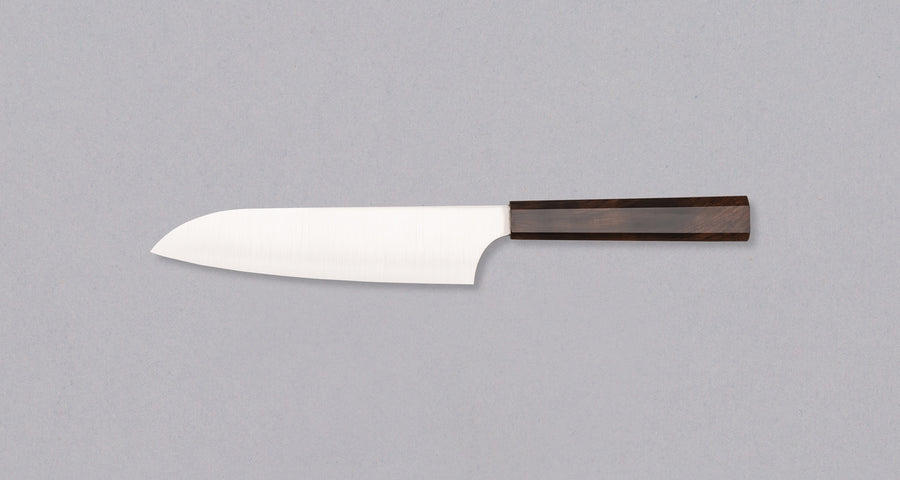 Nož Hayabusa Santoku Aogami Super 180 mm je prava izbira za ljubitelje japonskih kuhinjskih mojstrovin. Santoku oblika rezila zagotavlja vsestranskost pri rezanju zelenjave, mesa in rib. Rezilo iz visokokakovostnega Aogami Super jekla s trdoto 63 HRC ohranja izjemno ostrino in natančnost, hkrati pa ima čudovit migaki videz in edinstvene japonske pismenke, ki poudarjajo tradicijo in slog. Osemkotni ročaj iz temne ebenovine nudi stabilen in udoben oprijem za popoln nadzor.