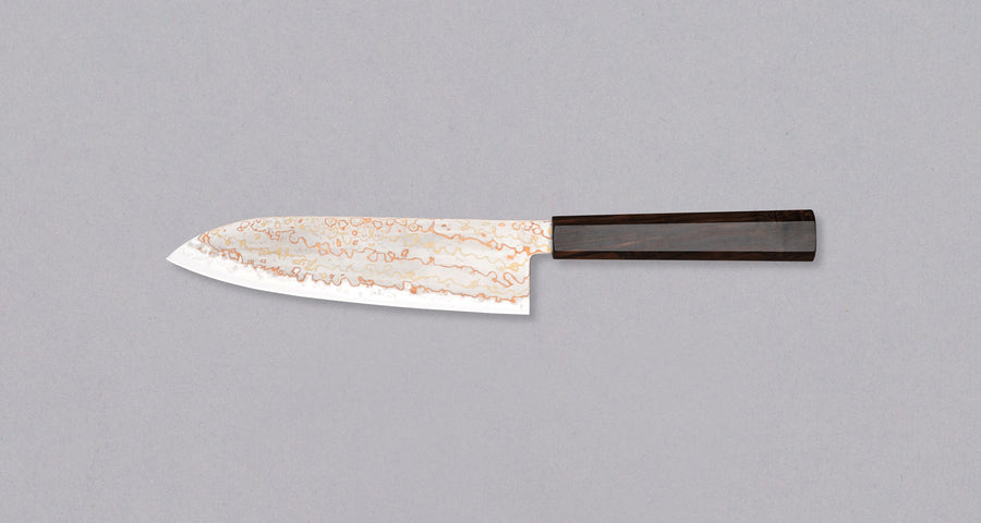 Hayabusa Santoku Aogami #2 Rainbow Damascus 180 mm je nož za vsestransko uporabo v kuhinji, primeren za meso, ribe in zelenjavo. Tanko rezilo je narejeno iz Aogami #2 jekla, znanega po dolgem ohranjanju ostrine in lahkosti brušenja. Ima unikaten barvit damaščanski vzorec, izdelan s plastenjem medenine in bakra.