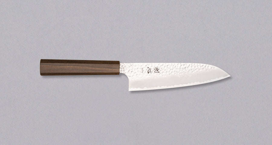 Hayabusa Santoku VG-10 Tsuchime Bubinga 180 mm nož z izjemno tankim rezilom in tsuchime finišem, ki prikazuje majhne okrogle vdolbinice na površini.
