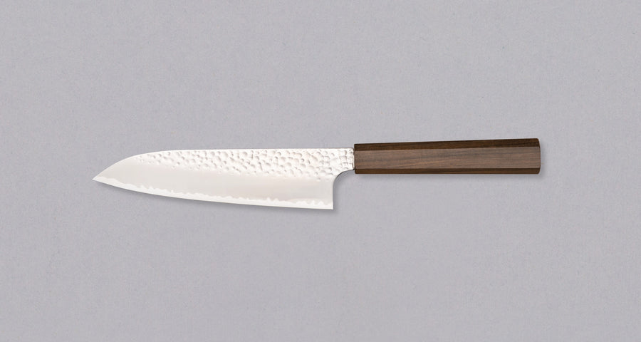 Hayabusa Santoku VG-10 Tsuchime Bubinga 180 mm nož z izjemno tankim rezilom in tsuchime finišem, ki prikazuje majhne okrogle vdolbinice na površini.
