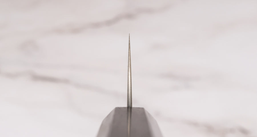 Nož Hayabusa Gyuto Aogami Super 210 mm je prava izbira za ljubitelje japonskih kuhinjskih mojstrovin. Gyuto oblika rezila zagotavlja vsestranskost pri rezanju mesa, zelenjave in rib, zato je odličen pripomoček za različne rezalne tehnike. Rezilo iz visokokakovostnega Aogami Super jekla s trdoto 63 HRC ohranja izjemno ostrino in natančnost, hkrati pa ima čudovit migaki videz in edinstvene japonske pismenke, ki poudarjajo tradicijo in slog. Osemkotni ročaj iz temne ebenovine nudi stabilen in udoben oprijem.