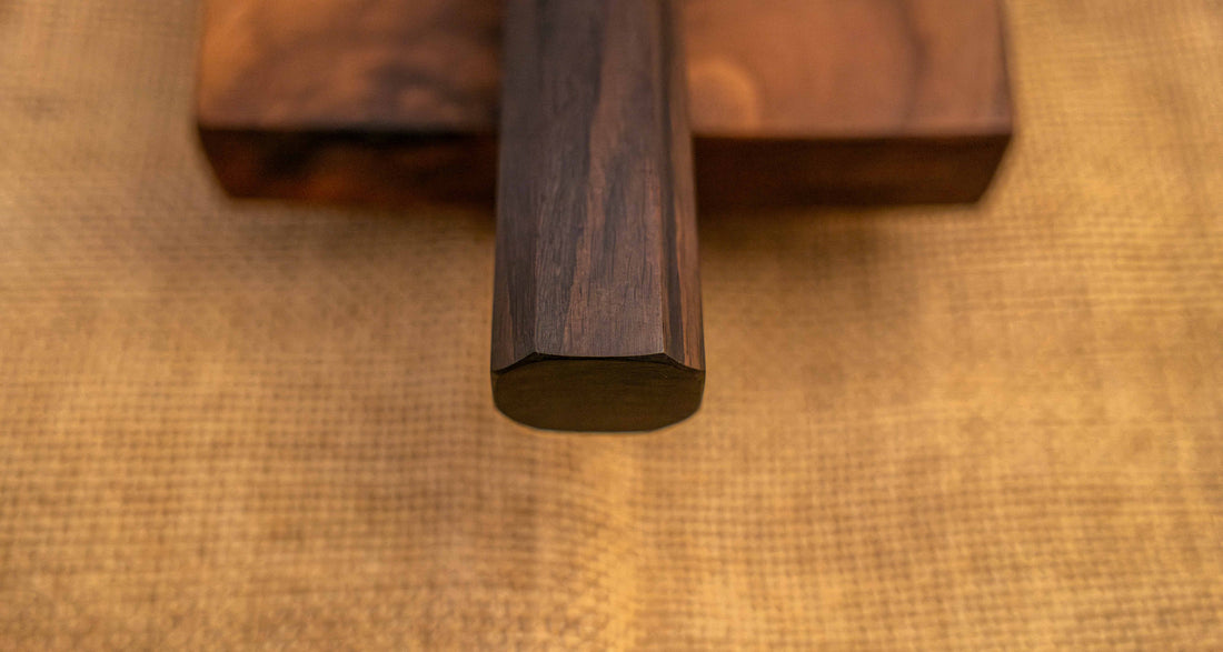 Pogled na ročaj Hayabusa Gyuto VG-10 Tsuchime Damascus Ebony 210 mm, izdelan iz temnega ebenovega lesa v wa-stilu, zagotavlja udoben in stabilen oprijem za popoln nadzor pri rezanju.