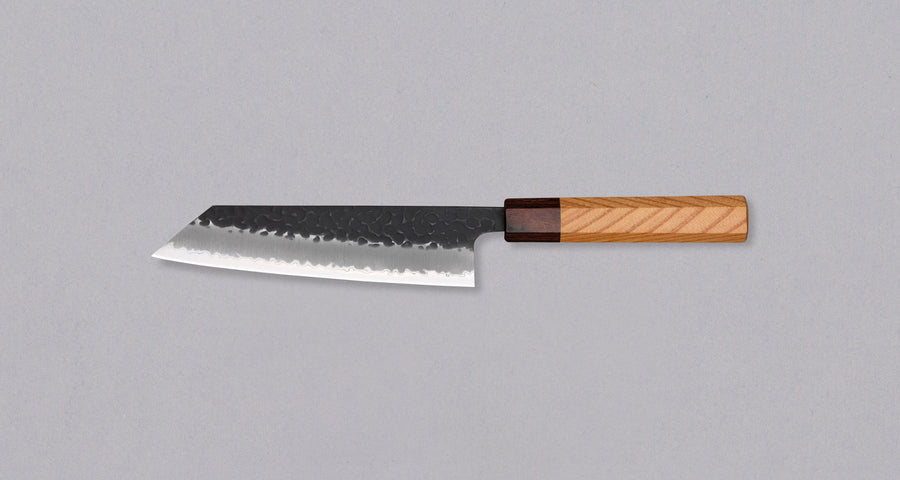 Japonski nož Hokiyama Bunka Aogami Super Kuro-uchi 170 mm je večnamenski nož iz Aogami Super jekla, ki dolgo časa drži ostrino. Kuro-uchi patina ga ščiti pred korozijo, odtisi kladiv pa preprečujejo lepljenje hrane na rezilo. Ima tradicionalni japonski wa ročaj oktagonalne oblike iz mahagonija in zelkovega lesa.