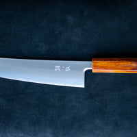 Nož Hokiyama Gyuto SRS13 Migaki 210 mm je odlična izbira za vse profesionalne kuharje in kuharje po duši, ki imajo radi rezila, ki dolgo držijo ostrino, so izjemno ostri, hkrati pa niso zahtevni za vzdrževanje. Tradicionalno japonsko minimalističen videz rezila odlično dopolnjuje eleganten hrastov ročaj Urushi Flame.