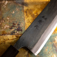 Detajl rezila iz ebenovine noža Kokugei Gyuto Aogami #1 Kuro-uchi 240 mm, ki nudi udoben in stabilen oprijem za popoln nadzor med uporabo.