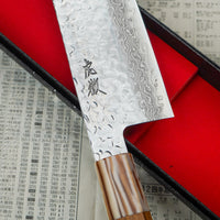 Kotetsu Santoku VG-10 Damascus 180 mm je velik vsestranski kuhinjski nož z vidnimi odtisi kladiv, damascus vzorcem in klasičnim japonskim ročajem (wa-style) iz tikovine. Navdušil bo vse, ki cenijo estetsko oblikovane kuhinjske pripomočke. Primeren je za pripravo mesa, rib in zelenjave.