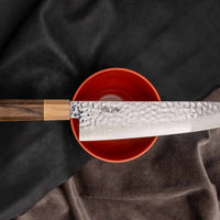 Kotetsu Gyuto VG-10 Damascus 210 mm je velik vsestranski kuhinjski nož z vidnimi odtisi kladiv, damascus vzorcem in klasičnim japonskim ročajem (wa-style) iz pakka lesa. Navdušil bo vse, ki cenijo estetsko oblikovane kuhinjske pripomočke.