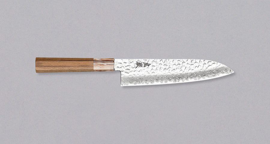 Kotetsu Santoku VG-10 Damascus 180 mm je velik vsestranski nož z vidnimi odtisi kladiv, damascus vzorcem in klasičnim japonskim ročajem (wa-style) iz tikovine. Je izjemno tanek (1,7 mm), zato bo zlahka zdrsel skozi sestavine, nerjaveče VG-10 jeklo pa zagotavlja odpornost na rjo, trpežnost in odpornost proti obrabi.